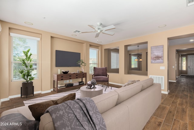 living room with ceiling fan and dark hardwood / wood-style flooring