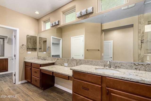 bathroom with wood-type flooring, vanity, and a shower with door