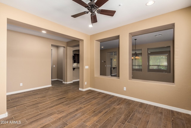 unfurnished room featuring ceiling fan and dark wood-type flooring