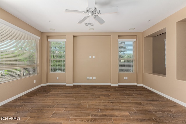 spare room with dark wood-type flooring and ceiling fan