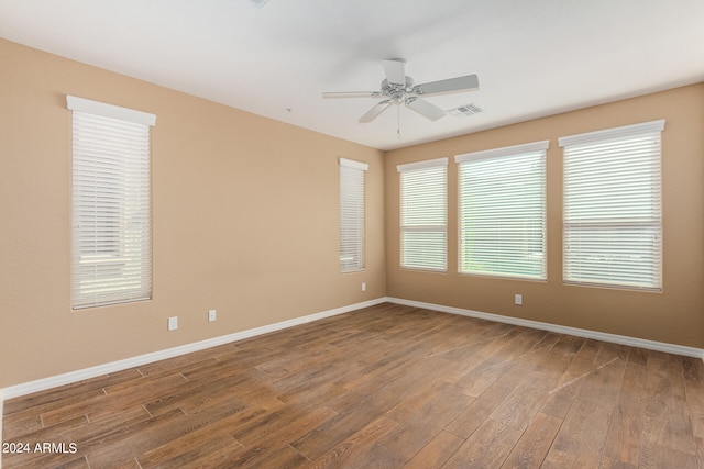 unfurnished room with ceiling fan, hardwood / wood-style flooring, and a wealth of natural light