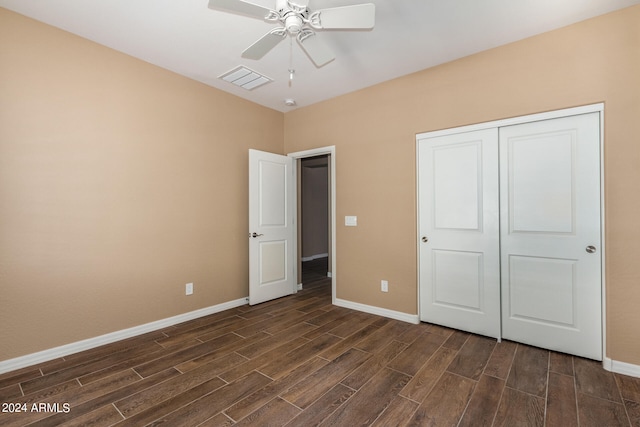 unfurnished bedroom featuring dark wood-type flooring, a closet, and ceiling fan