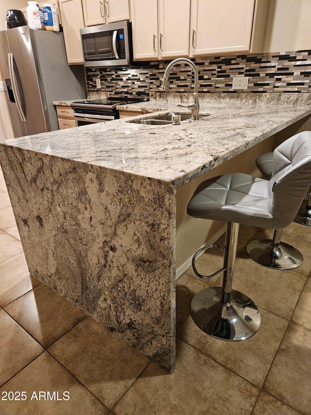 205 N 74th St Unit 166, Mesa, AZ 85207 - kitchen featuring stainless steel appliances, tile patterned flooring, light stone countertops, and backsplash