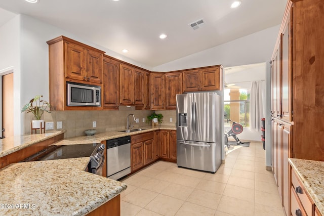 kitchen featuring light stone counters, appliances with stainless steel finishes, sink, and backsplash