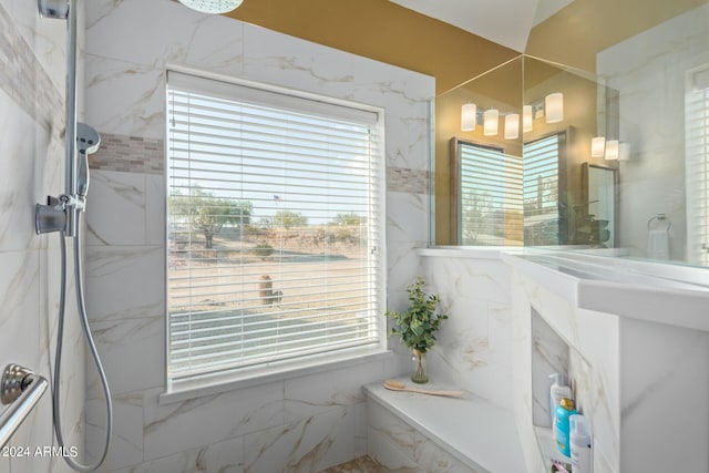 bathroom featuring plenty of natural light and tiled shower