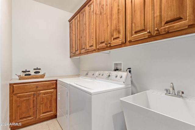 laundry area with separate washer and dryer, sink, light tile patterned floors, and cabinets