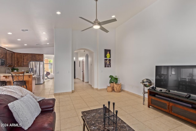 tiled living room featuring ceiling fan and high vaulted ceiling