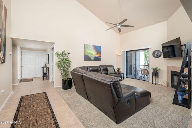 living room with ceiling fan, a fireplace, high vaulted ceiling, and light tile patterned flooring