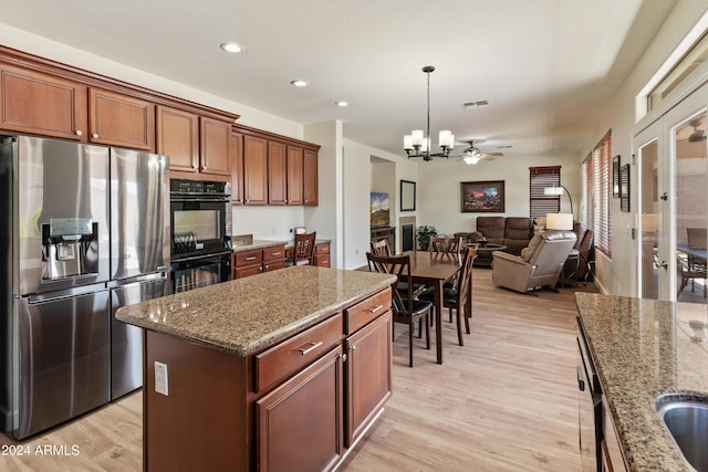 kitchen with a kitchen island, pendant lighting, double oven, stainless steel refrigerator with ice dispenser, and light wood-type flooring