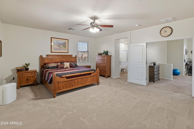 carpeted bedroom featuring ensuite bath and ceiling fan