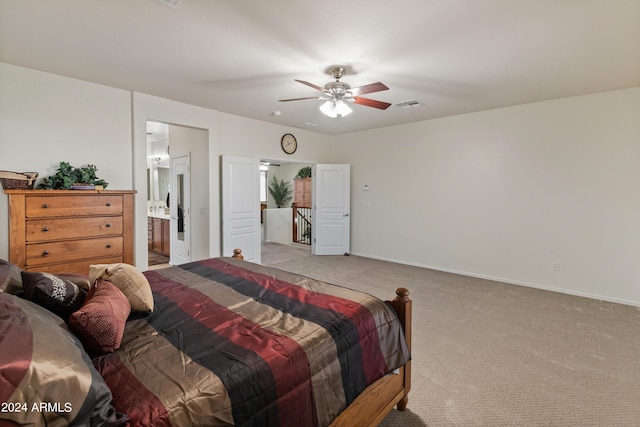 bedroom featuring ceiling fan, connected bathroom, and light carpet