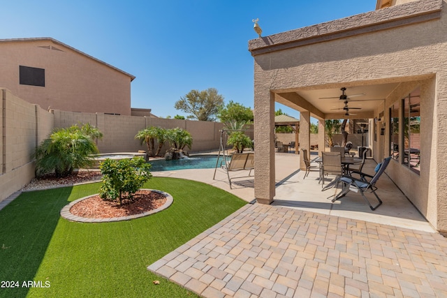 view of yard with a fenced in pool, a patio area, and ceiling fan