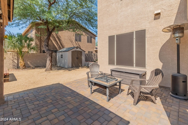 view of patio with a storage unit and a fire pit