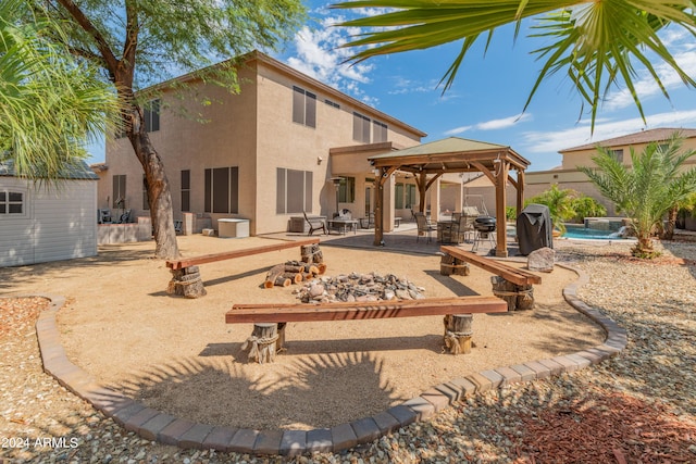 back of house with a fenced in pool, a gazebo, a patio area, a storage unit, and pool water feature