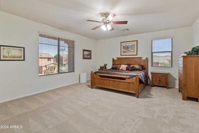 carpeted bedroom with multiple windows and ceiling fan