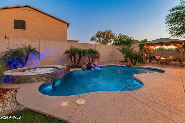 pool at dusk with a gazebo, an in ground hot tub, and a patio area