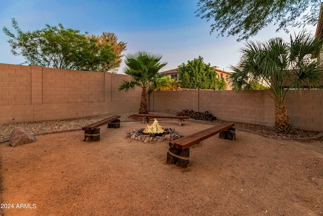 yard at dusk featuring an outdoor fire pit