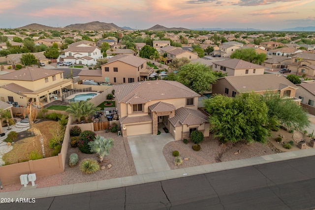 aerial view at dusk featuring a mountain view