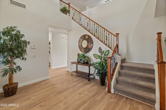 staircase with a high ceiling and hardwood / wood-style floors