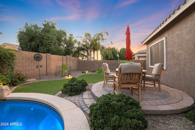 pool at dusk featuring a patio area