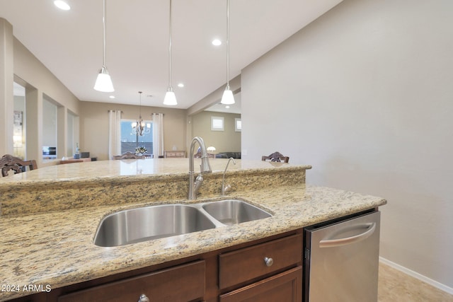 kitchen featuring pendant lighting, an inviting chandelier, light stone countertops, and sink