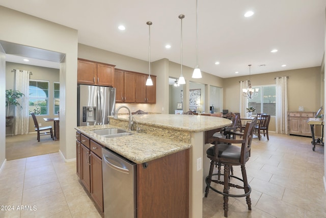 kitchen featuring appliances with stainless steel finishes, hanging light fixtures, sink, and a healthy amount of sunlight