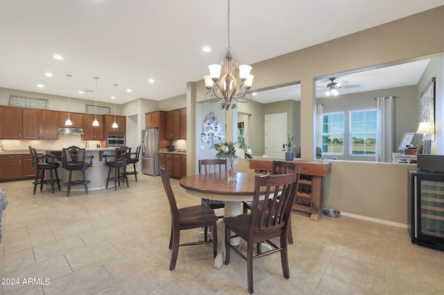 dining area with wine cooler, ceiling fan with notable chandelier, and light tile patterned floors