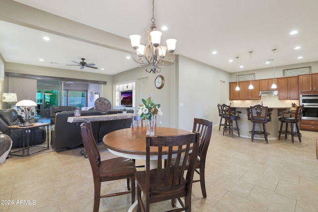 dining area featuring ceiling fan with notable chandelier