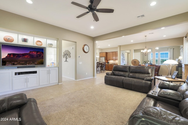 living room with ceiling fan with notable chandelier and light tile patterned floors