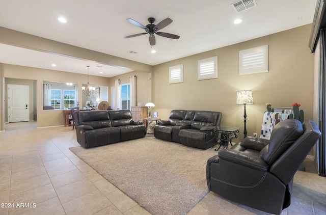 living room with ceiling fan with notable chandelier and light tile patterned floors