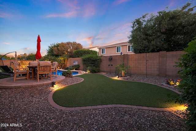 yard at dusk featuring a fenced in pool and a patio area