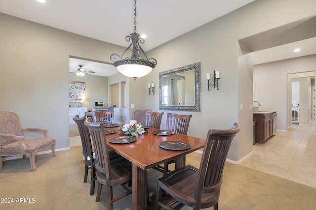 dining room with ceiling fan, light colored carpet, and sink