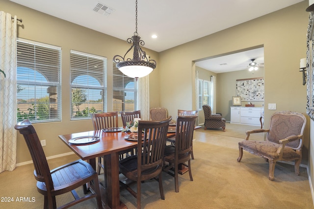 carpeted dining room featuring ceiling fan and a wealth of natural light