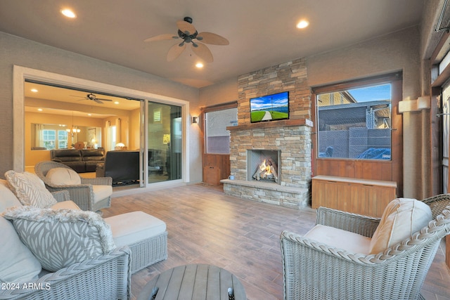 living room with ceiling fan, hardwood / wood-style flooring, and a fireplace