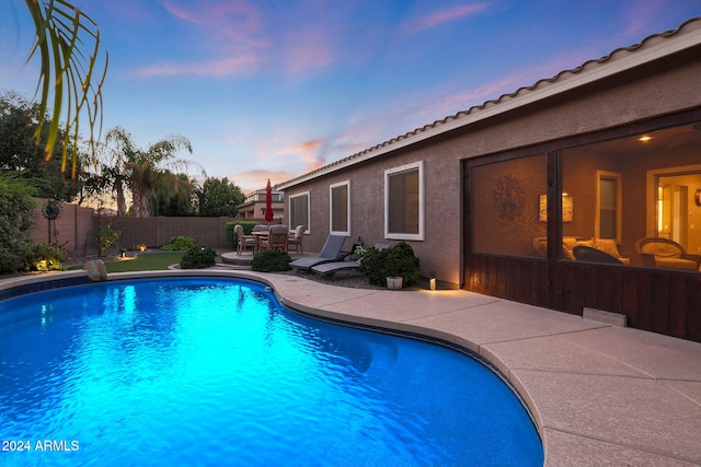 pool at dusk with a patio