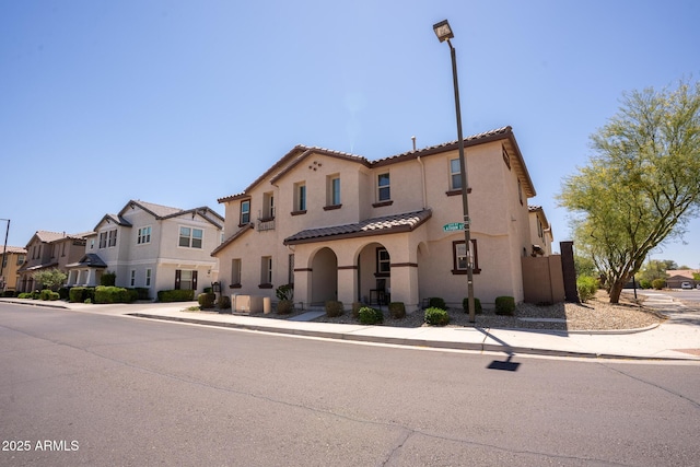 16425 W Latham St, Goodyear, AZ 85338 - view of front of house featuring stucco siding, a tiled roof, and a residential view