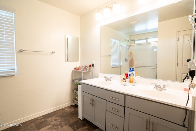 16425 W Latham St, Goodyear, AZ 85338 - bathroom featuring a stall shower, baseboards, and double vanity