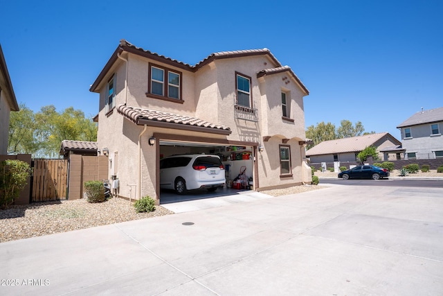 16425 W Latham St, Goodyear, AZ 85338 - mediterranean / spanish-style house with a garage, a tiled roof, concrete driveway, stucco siding, and a gate