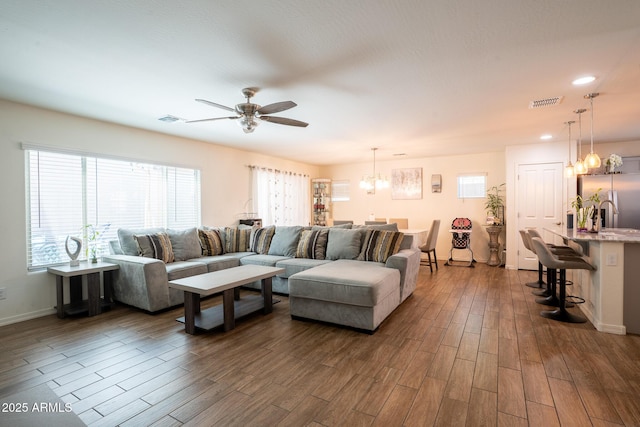 16425 W Latham St, Goodyear, AZ 85338 - living area with a chandelier, dark wood finished floors, a ceiling fan, baseboards, and recessed lighting