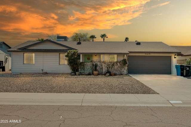 ranch-style home featuring central AC unit, a porch, concrete driveway, and an attached garage