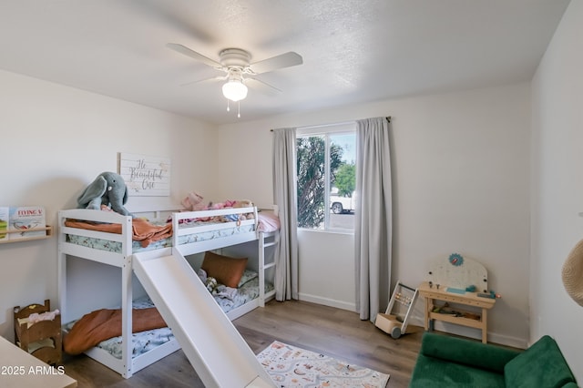 bedroom featuring a ceiling fan, wood finished floors, and baseboards