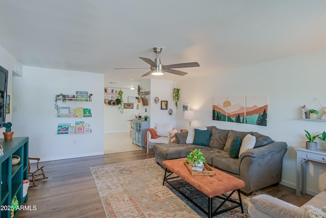 living room featuring a ceiling fan, wood finished floors, and baseboards