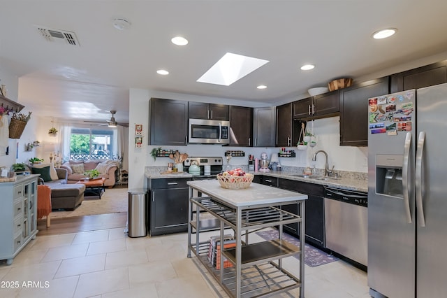 kitchen featuring visible vents, a sink, dark brown cabinets, appliances with stainless steel finishes, and open floor plan