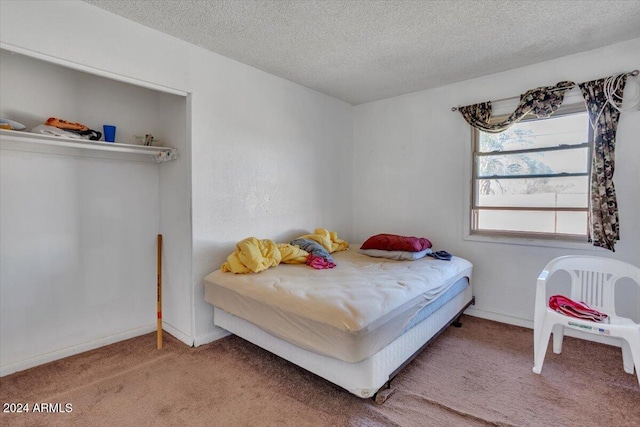 bedroom with a textured ceiling and carpet flooring