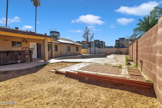 view of yard with a patio area and a storage shed