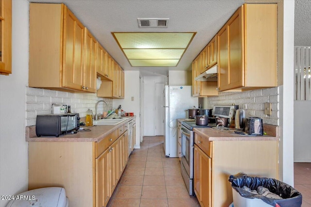 kitchen featuring stainless steel range with electric stovetop, light tile patterned flooring, a textured ceiling, and sink