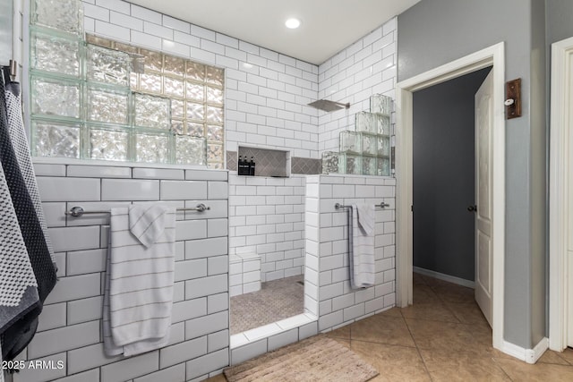 bathroom featuring tile patterned floors and a tile shower