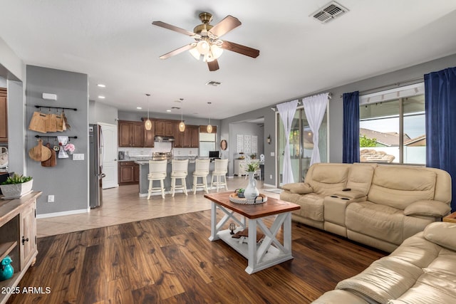 living room with dark wood-type flooring and ceiling fan