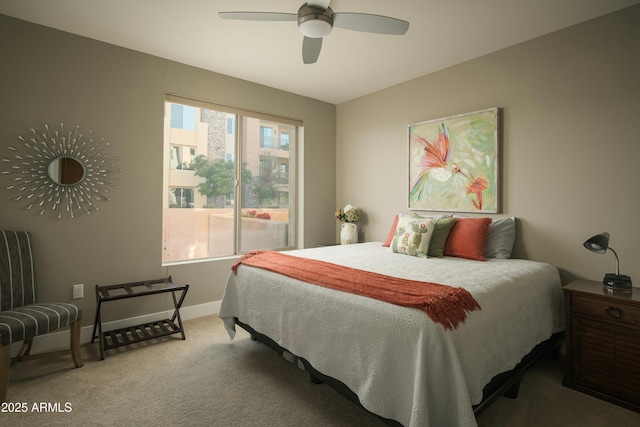 carpeted bedroom with ceiling fan and baseboards