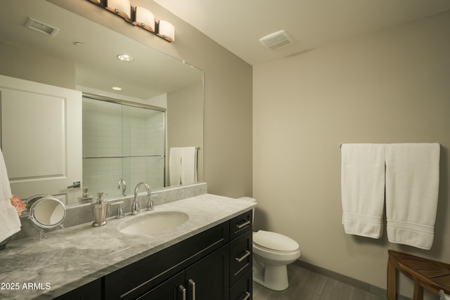 bathroom with toilet, vanity, a shower stall, and visible vents